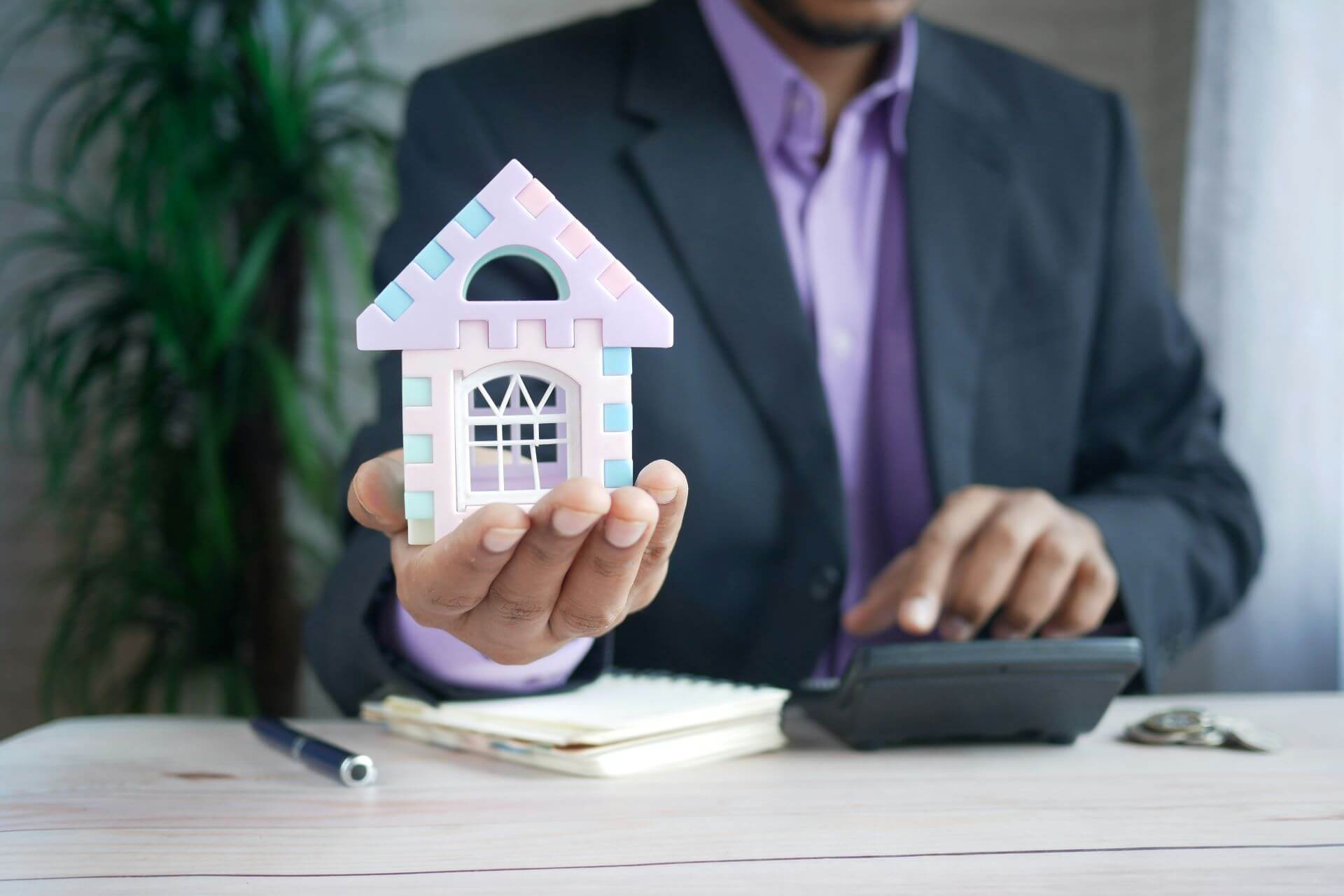 Miniature House and Man with Calculator